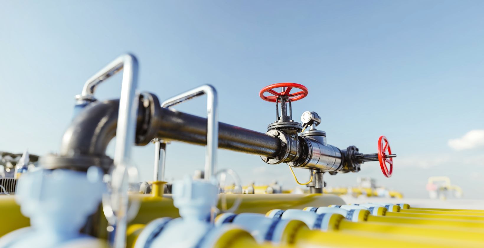 Live gas pipeline with red handwheel isolation valves and a pressure gauge at a UK gas facility, ready for hot tapping