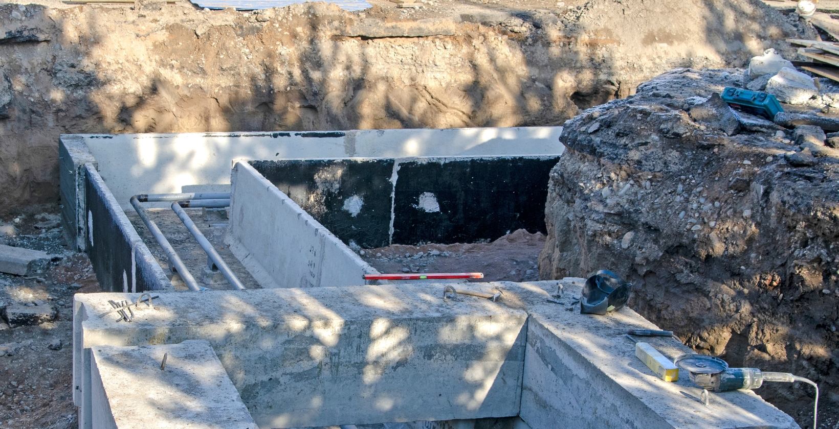 Excavated trench with concrete ducting and underground gas service pipework being installed on a UK site